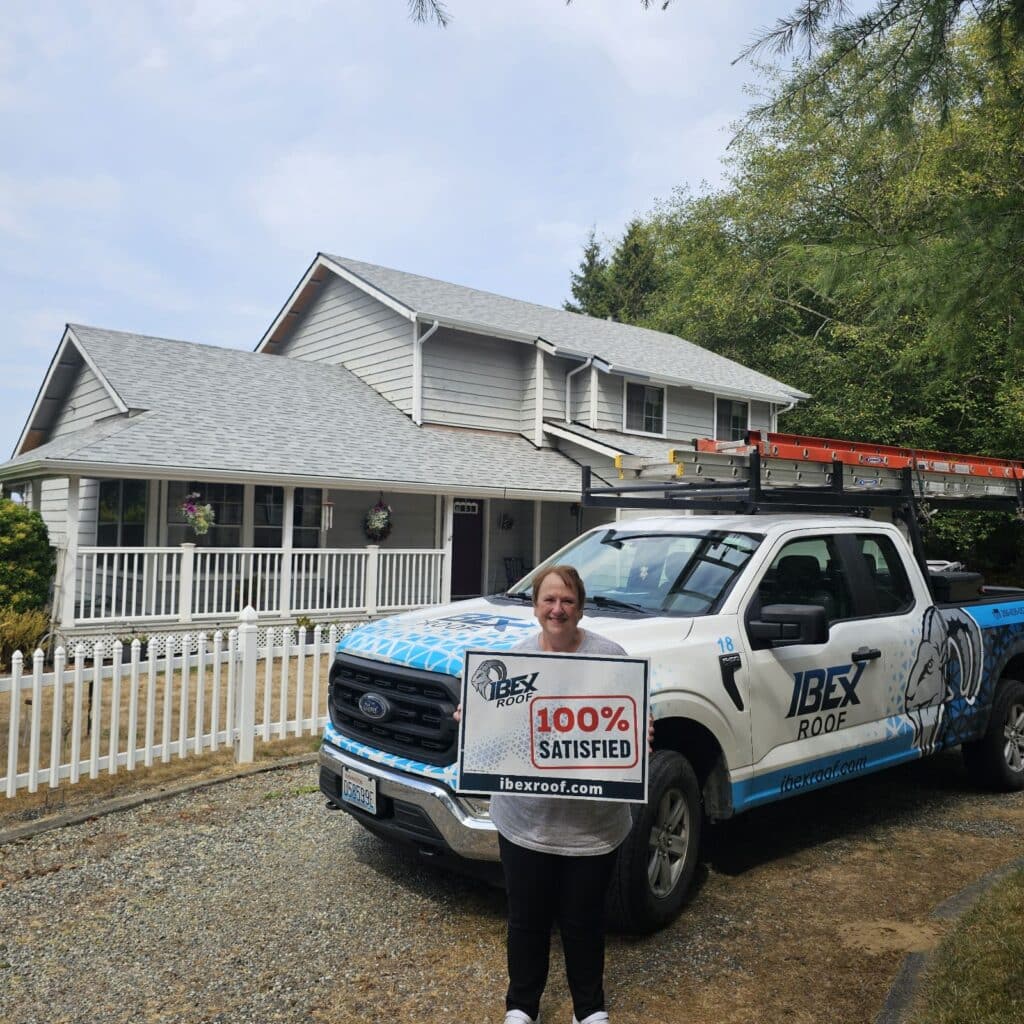 IBEX Roof customer holding 100 percent satisfied sign beside company truck in front of a two story home