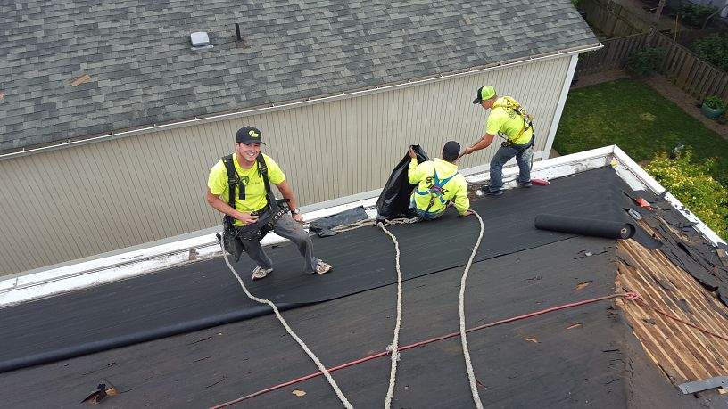 A group of roof contractors working on a residential roof.